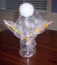 Cover a recycled water bottle with plastic wrap to craft a ghost
